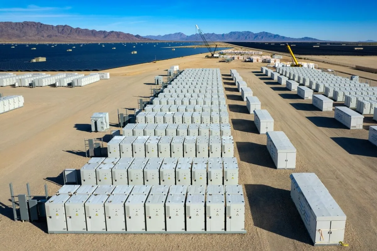 Ein Batteriepark mit einem Solarpark im Hintergrund.
