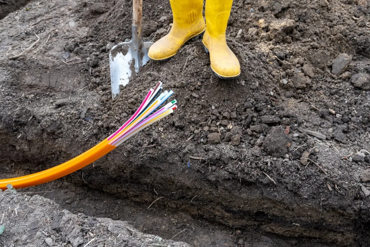 Aus dem Boden ragende Stromkabel und Bauarbeiten veranschaulichen die Einrichtung von Baustrom auf einer Baustelle.