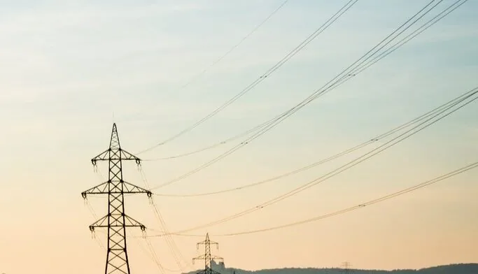 Der Strompreis kann stark variieren, Strommast in der Abenddämmerung.